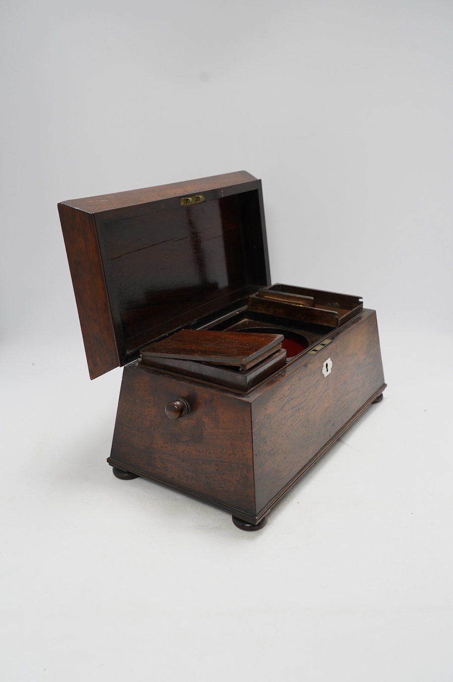 A Victorian rosewood sarcophagus shaped tea caddy with mother of pearl escutcheon, 33.5cm wide. Condition - fair, some internal damage